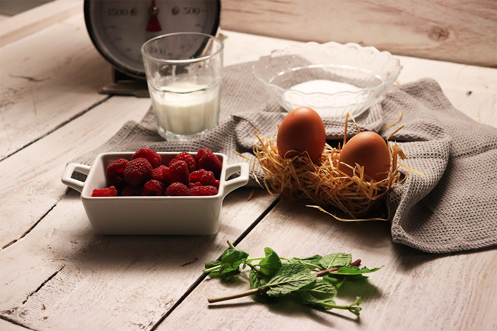 foto degli ingredienti per la mousse alla vaniglia, lamponi, uova, zucchero, panna, bilancia anni'50